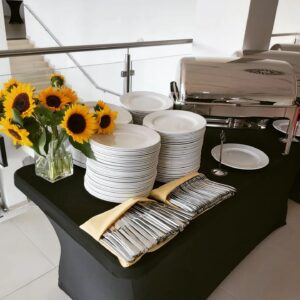 Przygotowany stół cateringowy z zastawą stołową i słonecznikami - catering Obieżyświat